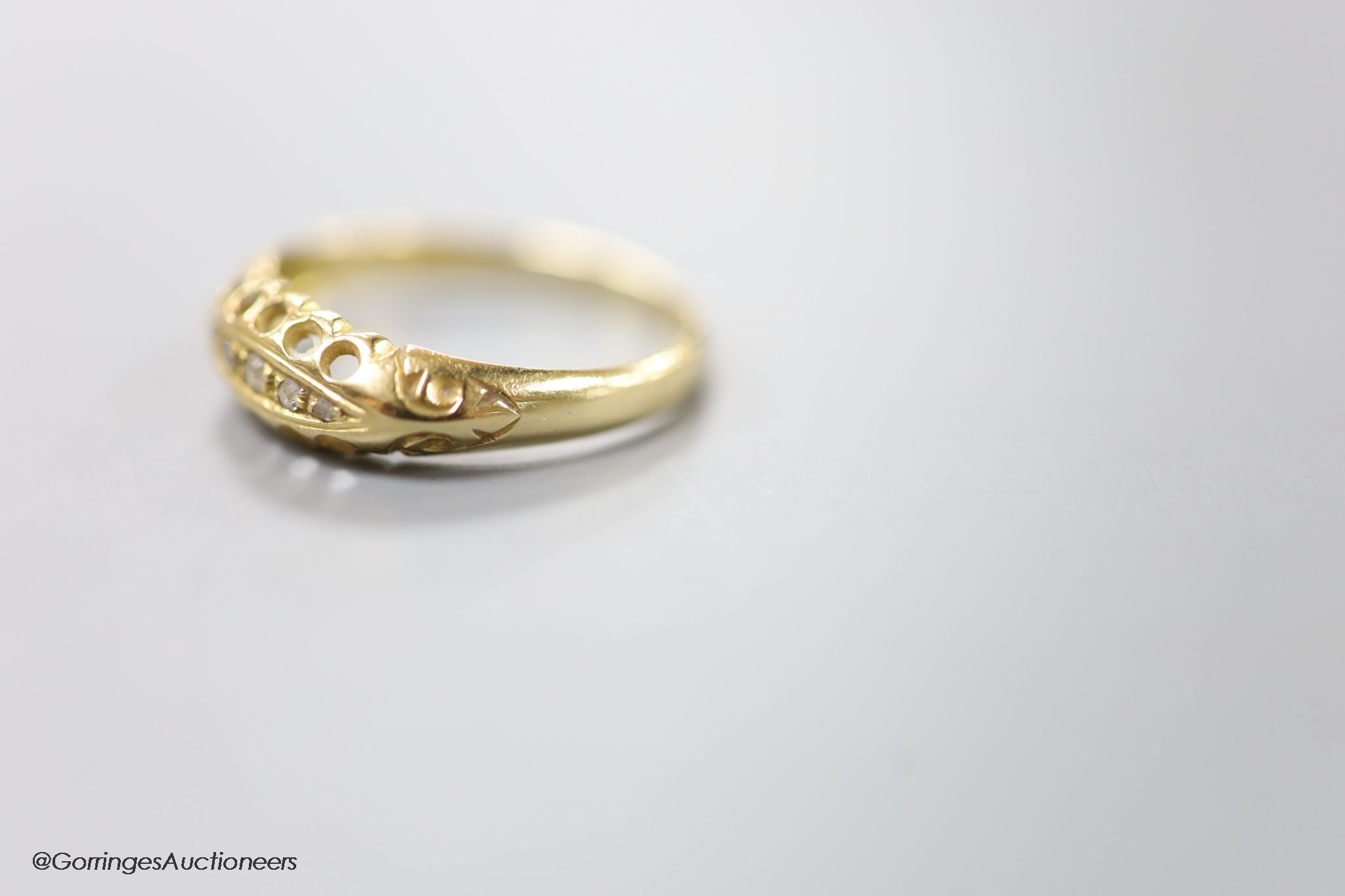 An Edwardian 18ct gold and five stone diamond chip set half hoop ring, size R, gross 2.6 grams